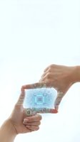 Hands holding transparent tablet displaying glowing circuit board and microchip technology interface for digital innovation and artificial intelligence applications.