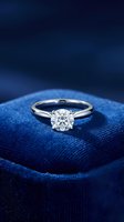 Elegant diamond solitaire engagement ring on luxurious blue velvet jewelry box for wedding proposal and romantic occasions.
