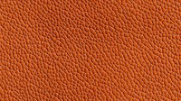 Textured orange leather background with natural grain pattern for fashion accessories, upholstery, or luxury product design.