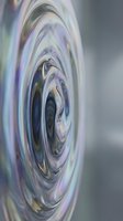 Abstract swirling vortex with iridescent colors creating hypnotic spiral pattern on blurred background for modern digital art and creative projects.