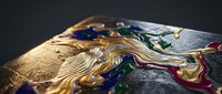 Abstract fluid art with golden metallic paint flowing over colorful acrylic surface creating dynamic waves and textures for modern design projects.