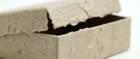 Cracked concrete block showing structural damage and weathering effects on construction material surface with visible fissures and deterioration.