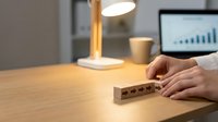 Professional businesswoman arranging wooden blocks with star ratings on office desk for customer feedback evaluation and quality assessment.