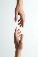 Two hands reaching toward each other on white background symbolizing connection, help, support, teamwork and human interaction for business concepts.