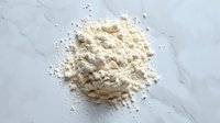 Pile of white flour powder scattered on marble surface for baking and cooking ingredients in kitchen preparation.