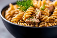 Delicious spiral pasta with mushrooms and fresh dill in black bowl, homemade comfort food ready to serve for lunch or dinner.
