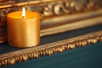 Golden candle burning on ornate vintage frame creating warm ambient lighting for relaxation and home decor atmosphere.