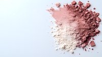 Crushed pink and nude cosmetic powder scattered on white background creating artistic makeup texture for beauty and fashion projects.