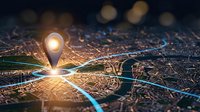 Glowing location pin marker on detailed city map with illuminated streets and navigation routes for GPS tracking and urban planning applications.