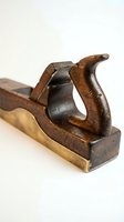 Vintage wooden hand plane carpentry tool with metal blade on white background for woodworking crafts and traditional construction projects.