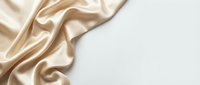 Luxurious beige silk fabric with soft folds and elegant drapes on white background, suitable for fashion, textile, and design projects.