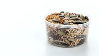 Mixed legumes and beans in glass container on white background isolated for healthy cooking and nutrition concepts.