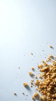 Scattered golden granola cereal pieces and crumbs dispersed across white background, ideal for food styling, breakfast advertising, and nutritional content design.