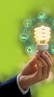Hand holding glowing energy-saving bulb with green technology icons: solar, wind, recycling, electric car, symbolizing sustainable innovation and eco future.