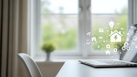Smart home technology concept with laptop displaying connected device icons on modern desk by window for automation and IoT applications.
