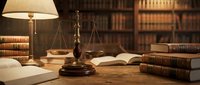 Brass scales of justice on wooden desk with open law books and warm lamp light in traditional library setting for legal consultation and attorney services.