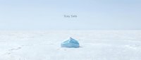 Blue disposable face mask lying on a vast white surface with Stay Safe text, minimalist health and safety concept for pandemic awareness.
