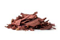 Pile of crushed dark chocolate shavings and flakes isolated on white background, macro shot with selective focus for culinary and confectionery designs.