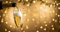 Champagne pouring into elegant flute glass with golden bokeh lights background for New Year celebration and festive occasions.