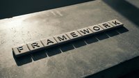 Wooden letter blocks spelling FRAMEWORK on concrete surface with dramatic shadows creating business concept for structure and organization.
