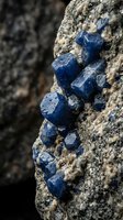 Blue mineral crystals embedded in rough stone matrix showcasing natural geological formation and raw gemstone texture for educational content.