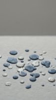 Smooth pebbles scattered on sandy beach surface creating natural zen composition for spa wellness meditation and mindfulness concepts.