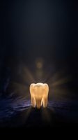 Glowing golden tooth with radiant light beams on dark textured surface for dental care, oral health and dentistry concepts.