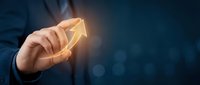 Businessman holding glowing upward arrow symbol representing growth, success, and financial progress in corporate strategy and investment planning.