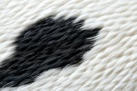 Abstract black and white natural fur texture showing contrasting colors and soft fluffy animal hair pattern in macro photography, suitable for luxury fashion designs.