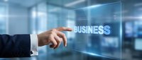 Businessman hand touching glowing business text on virtual screen in modern office, digital technology and corporate strategy concept.