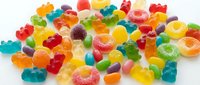 Colorful assorted gummy candies and jelly sweets scattered on white background. Sweet treats for parties, celebrations, and confectionery displays.