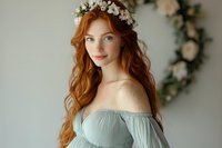 Young redhead woman wearing floral crown and sage green off-shoulder dress in romantic portrait setting with soft natural lighting for wedding photography.