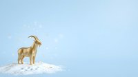 Golden goat standing on snowy hill against blue sky background, suitable for holiday and winter greeting cards.