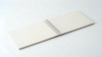 Open blank spiral notebook with clean white pages on white background, ready for writing, sketching, planning and creative projects.