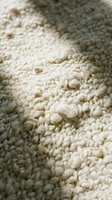 Soft cream colored wool carpet texture with natural fiber loops creating cozy home interior surface for flooring and decoration projects.