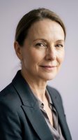 Mature woman with light brown hair, Caucasian ethnicity, wearing dark blazer over light shirt, professional headshot against lavender background for corporate or business use.