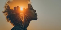 Double exposure silhouette of woman with afro hairstyle and urban cityscape at sunset, showing light trails and golden sun rays against neutral background.