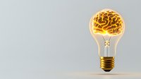 Glowing lightbulb with golden brain inside on light background symbolizes creativity, innovation, and bright ideas in business and education.