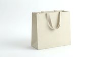 Blank cream paper shopping bag with handles isolated on white background for retail branding and packaging design mockup templates.