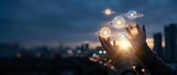 Hands holding glowing digital planets and spheres against night city skyline, representing global technology, innovation, and interconnected world networks for business concepts.