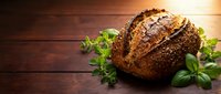 Freshly baked artisan bread loaf with seeds and herbs on rustic wooden table. Perfect for bakery, restaurant menus, cooking blogs, and food advertising.