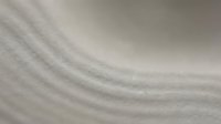 Soft white fabric texture with gentle flowing curves and natural wrinkles creating elegant drapery patterns for luxury textile and fashion design backgrounds.