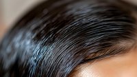 Close up view of dark hair with natural shine and texture showing healthy strands and scalp detail, suitable for hair care and beauty advertising.