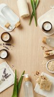 Spa and wellness products arranged on wooden surface with natural ingredients including lavender, aloe vera, oatmeal, and skincare creams in glass jars for beauty and relaxation themes.