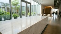 Modern office lobby with marble reception desk, floor-to-ceiling windows, and professional business interior design for corporate workspace environments.