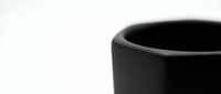 Black ceramic mug close-up on white background, minimalist kitchen tableware for coffee or tea drinking, modern home decor and beverage concept.