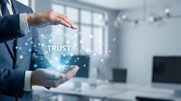 Businessman hands protecting glowing trust shield symbol with digital network connections in modern office environment for cybersecurity and business reliability.
