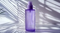 Purple cosmetic bottle with water drops on surface against white background with palm leaf shadow, minimalist spa and beauty product photography.