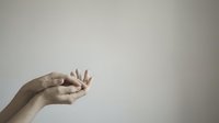 Cupped hands held open against a neutral background, symbolizing giving, receiving, hope, or prayer. Minimalist composition with copy space.