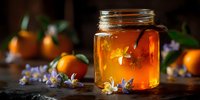 Golden honey in glass jar with orange citrus fruits and lavender flowers on rustic wooden table. Natural organic sweetener for cooking and wellness.